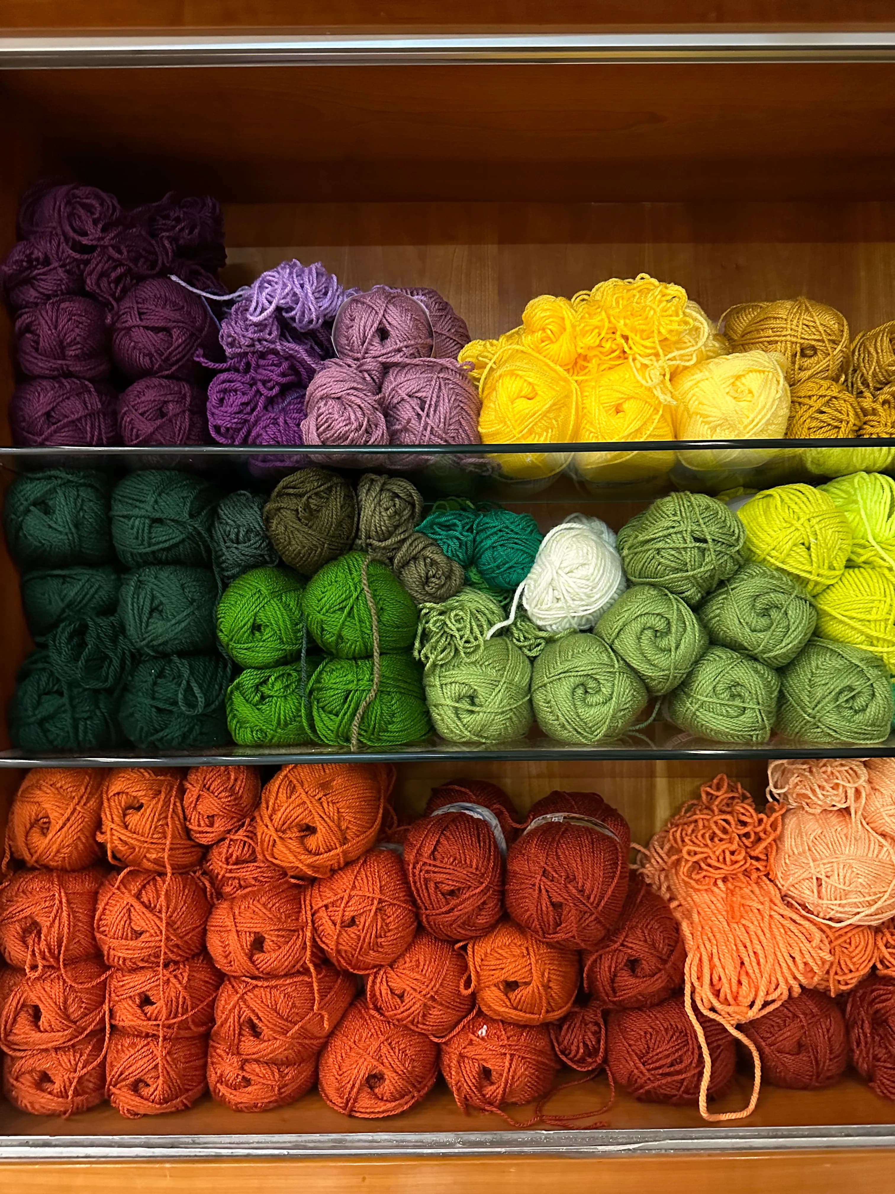 A person using a tufting gun to create a colorful rug design on a large frame